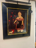 Framed artwork of a young girl with a black frame on a white wall.