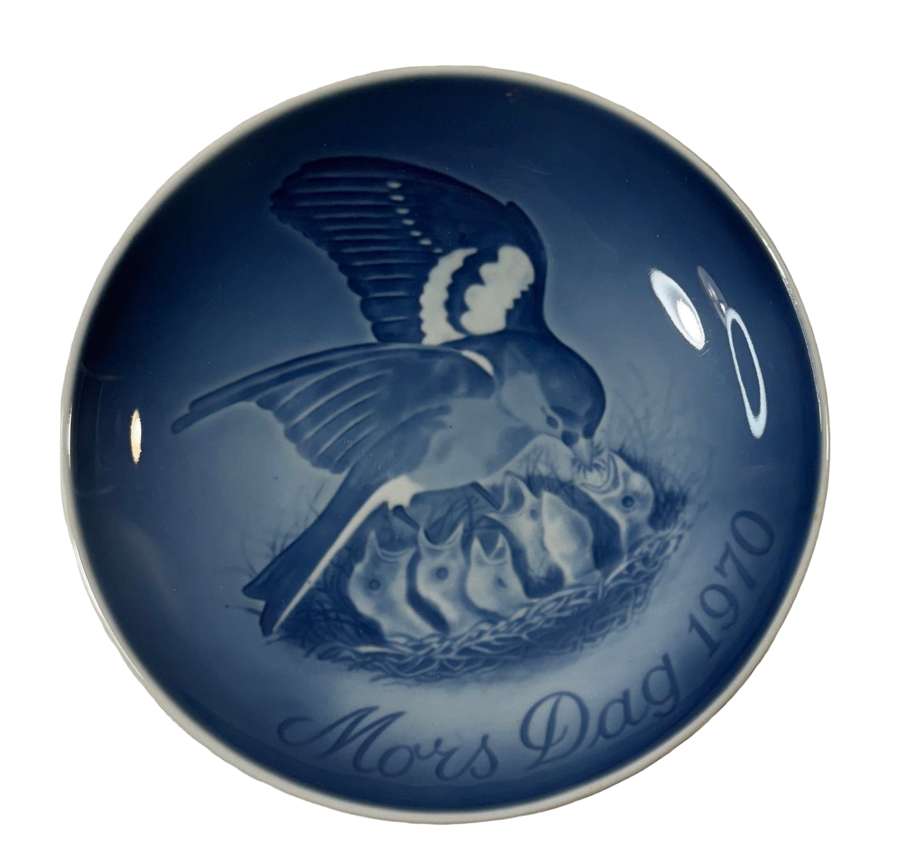 Blue ceramic plate with bird and chicks design and 'Mors Dag 1970' text on a textured surface.
