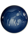 Blue ceramic plate with horse design and 'Mors Dag 1972' text on a textured beige background