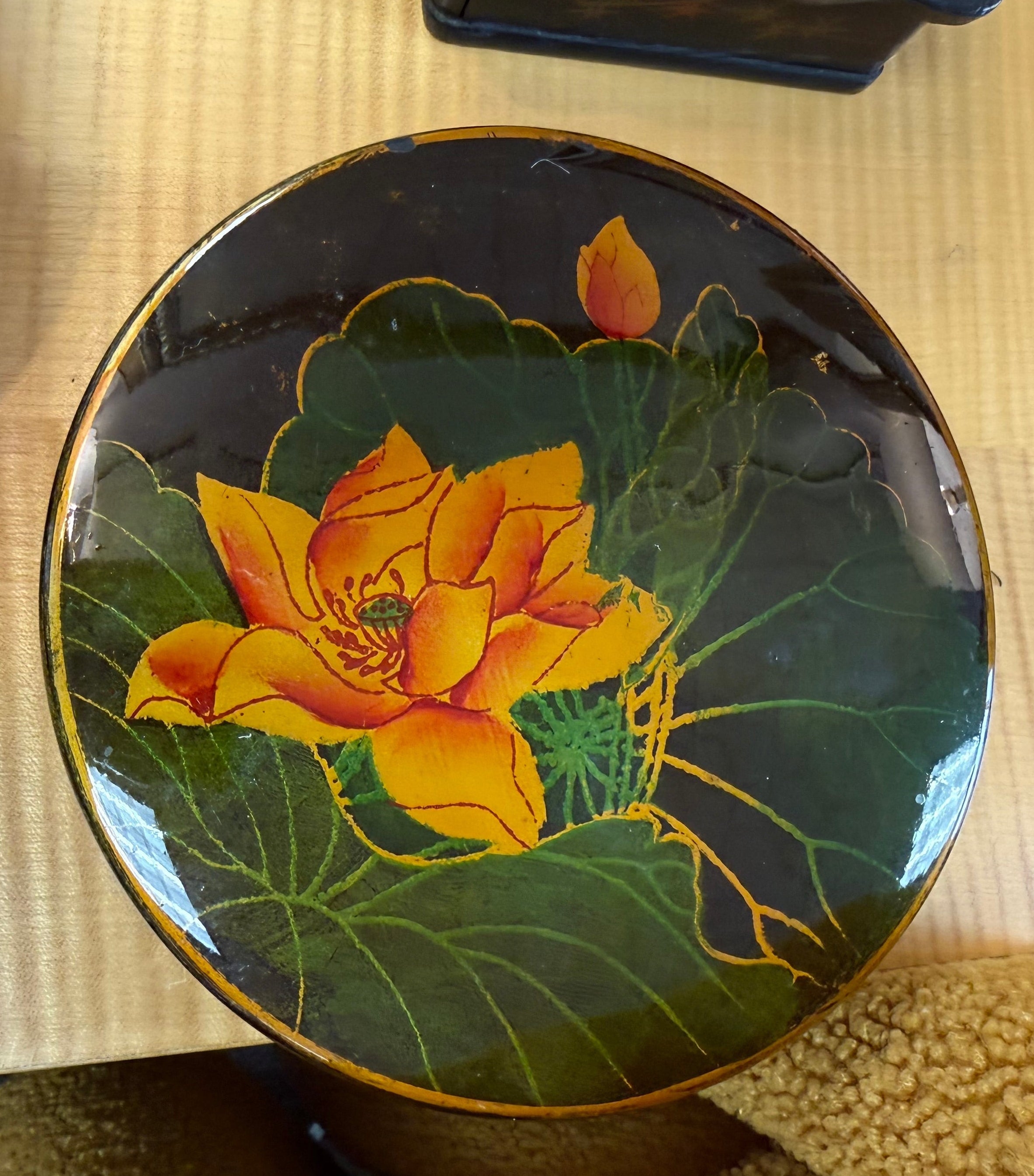 Decorative box with a yellow flower design on a wooden surface
