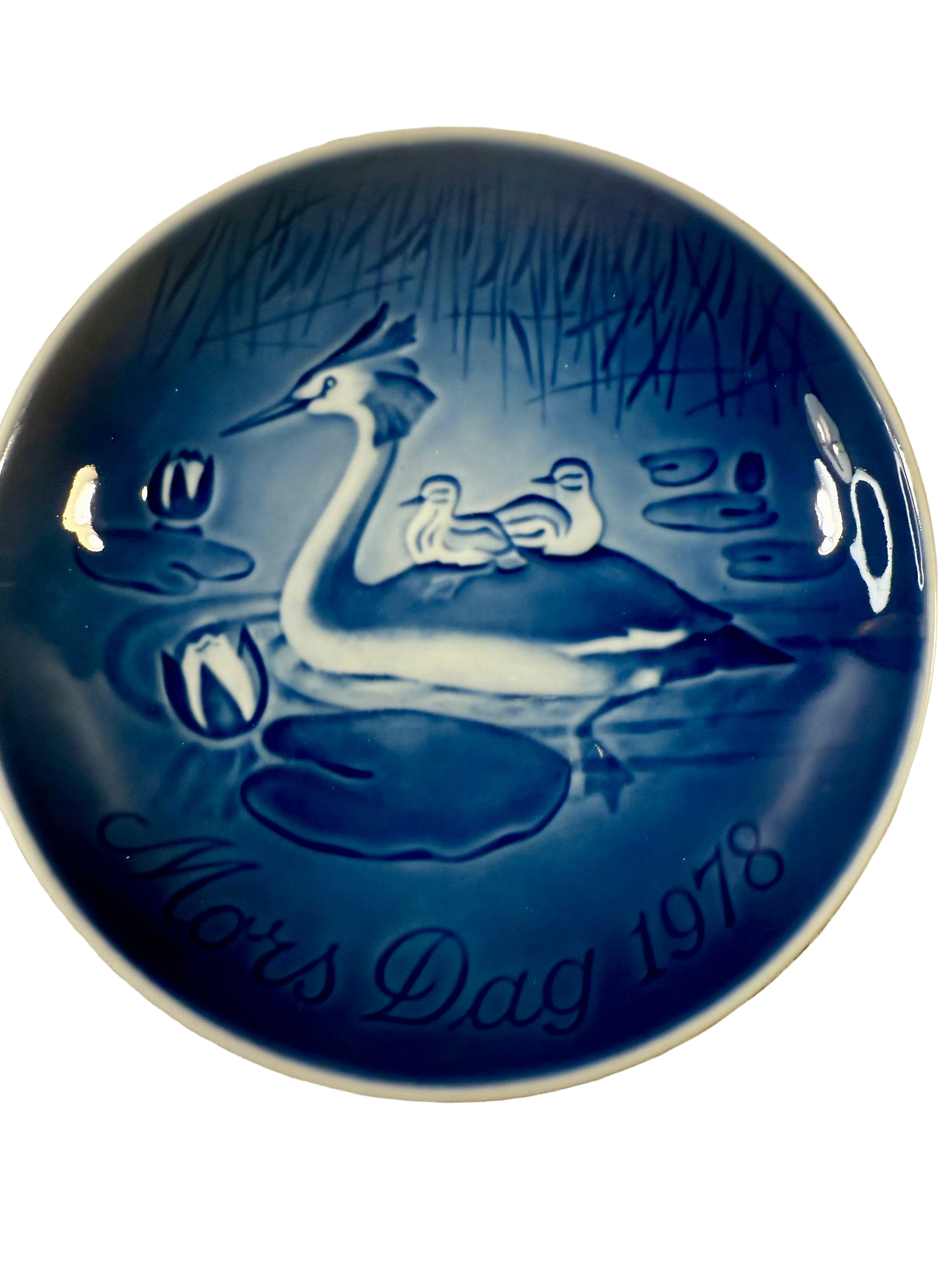 Blue ceramic plate with duck design and 'Mors Dag 1978' text on a textured beige background